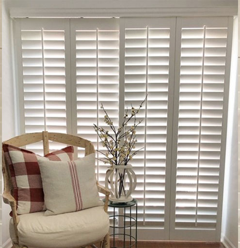 Sliding glass doors with white polywood shutters