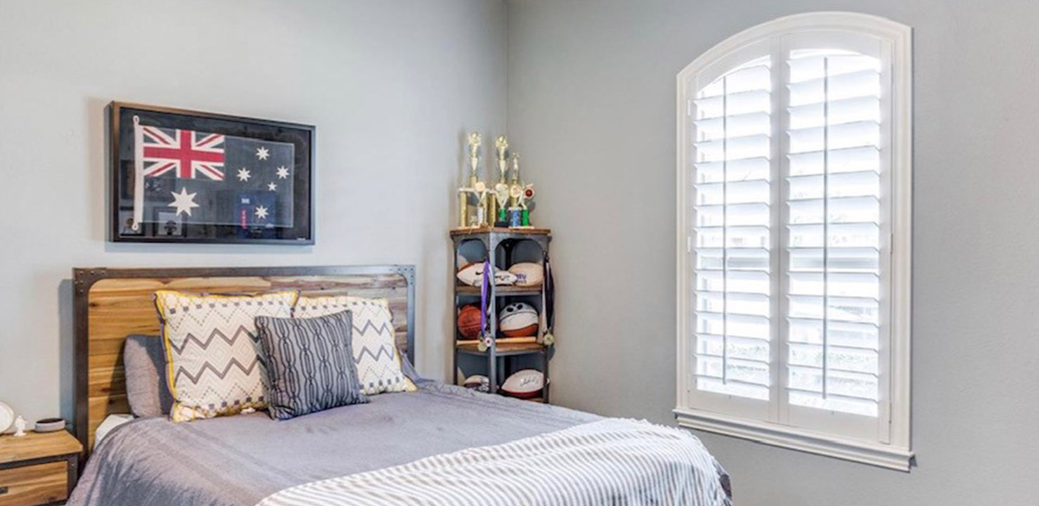 White polywood arched shutters in a bedroom